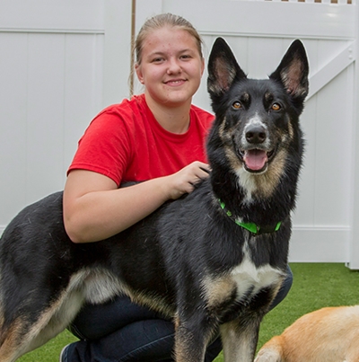 Camp Bow Wow camp counselor posing with dog