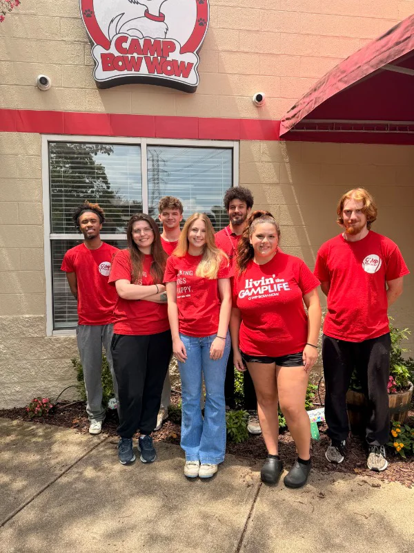 camp bow wow team in front of the storefront