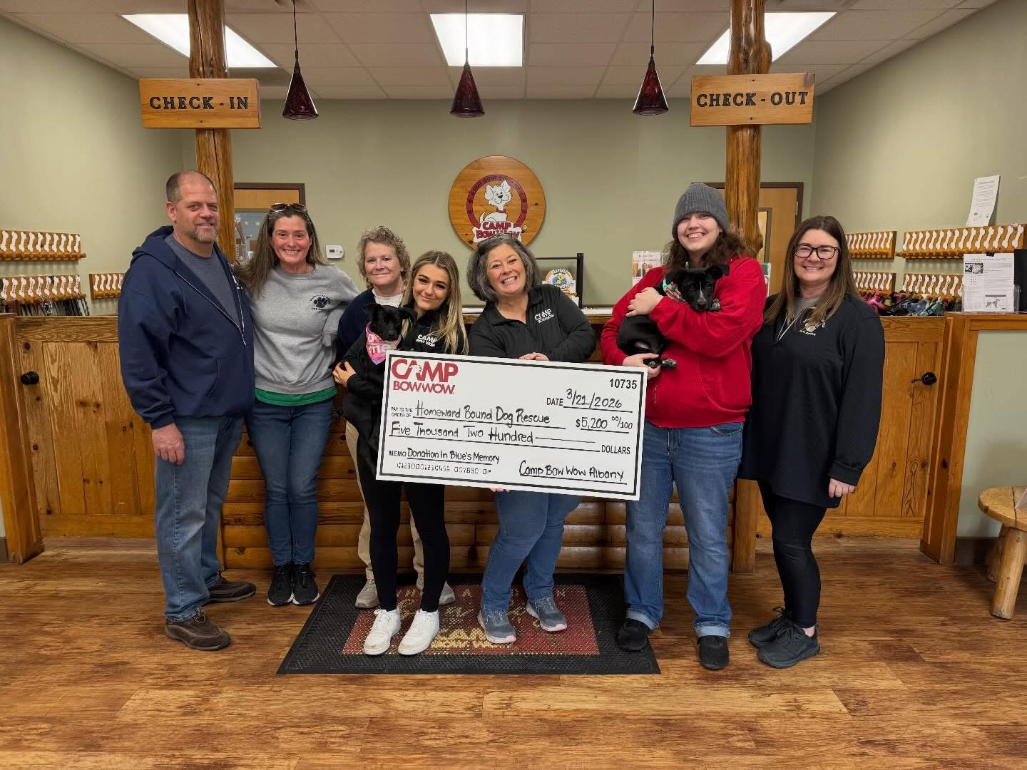 Camp Bow Wow Albany group photo holding a check and puppies