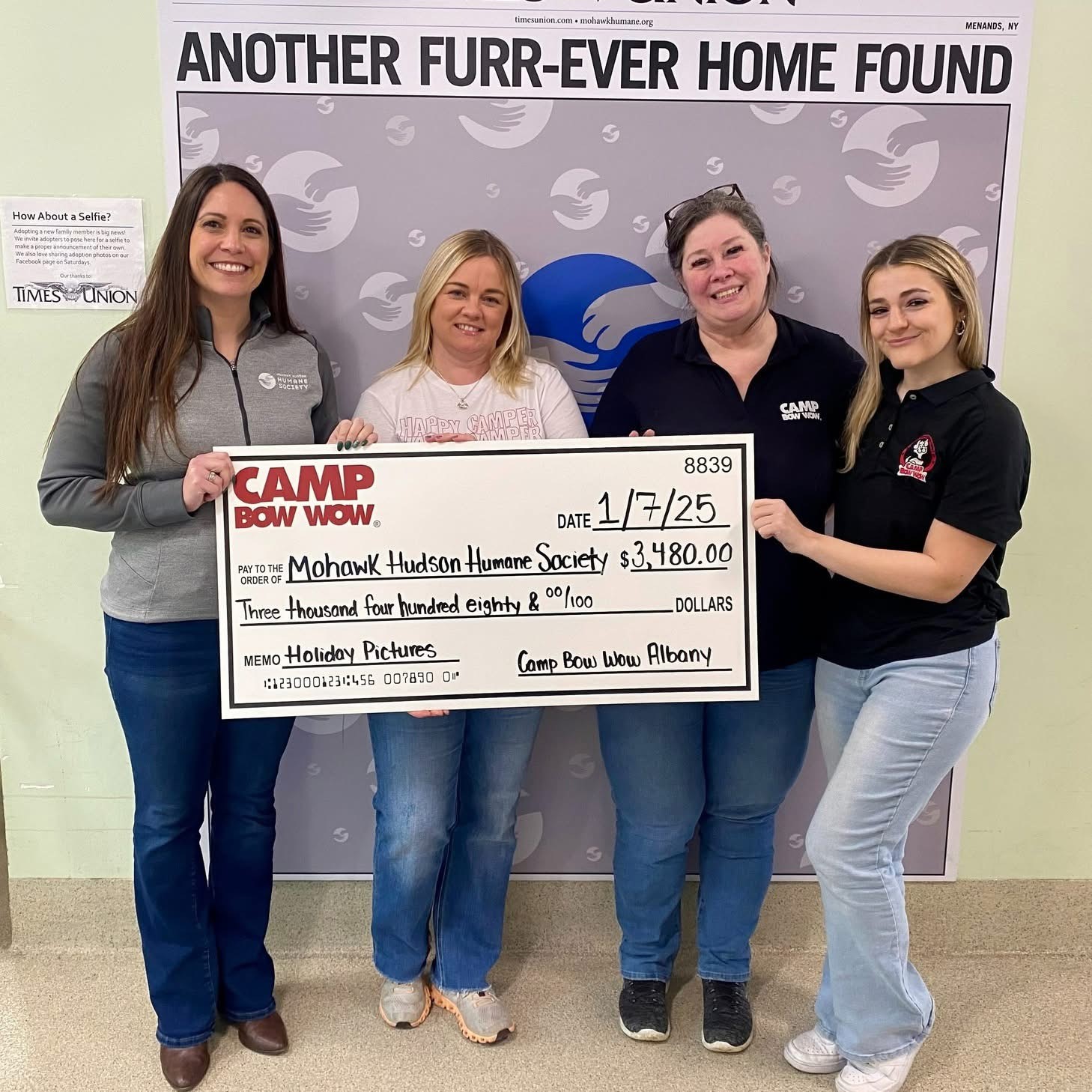 Camp Bow Wow Albany group photo holding a check and puppies